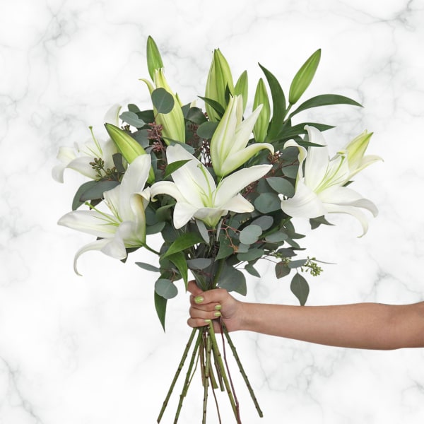 Handheld bouquet of white lilies with eucalyptus foliage