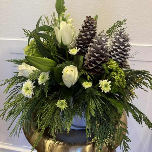 White roses and lilies with pinecones in a low arrangement
