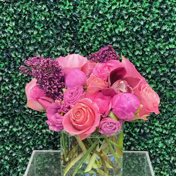 Pink and purple flower arrangement in a clear glass vase