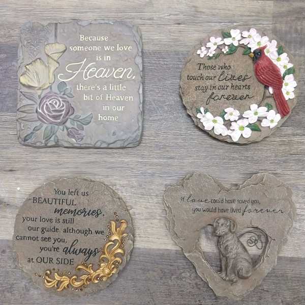 Four memorial stone plaques with floral accents and sympathy messages