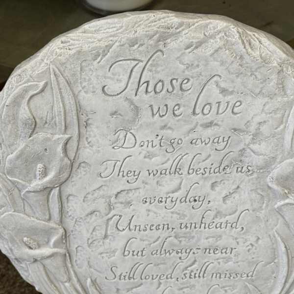 Round memorial plaque with engraved flowers and a sympathy poem