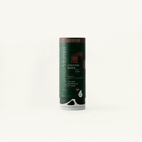 A cylindrical cocktail mixer container with dark green labeling
