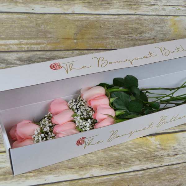 Pink roses in a white bouquet box