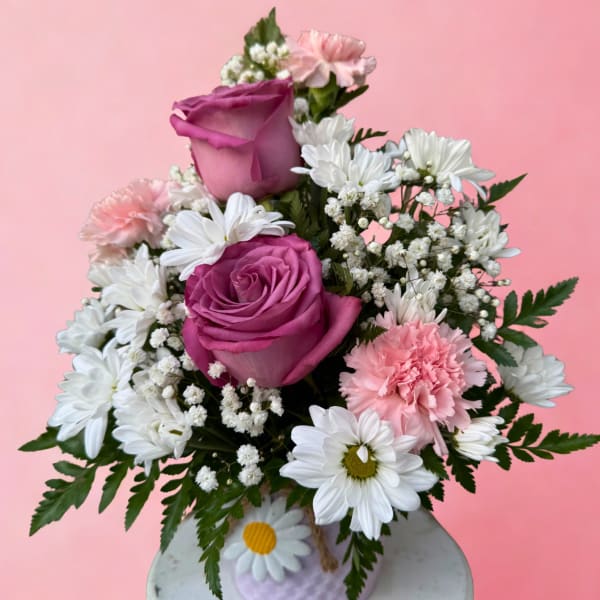 Pink and white bouquet with roses, daisies, and carnations in a small vase