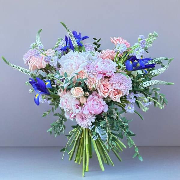 Hand-tied bouquet of pink and white flowers with blue irises