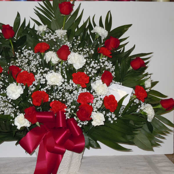 Red and white rose arrangement with baby's breath and a red ribbon