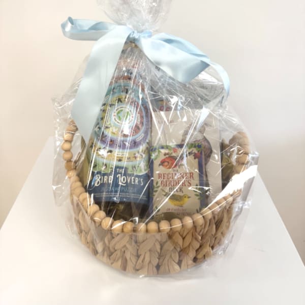 Gift basket with bird-themed books wrapped in clear cellophane and a blue ribbon