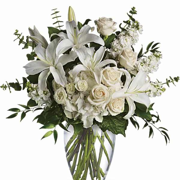 White lilies and roses in a clear glass vase