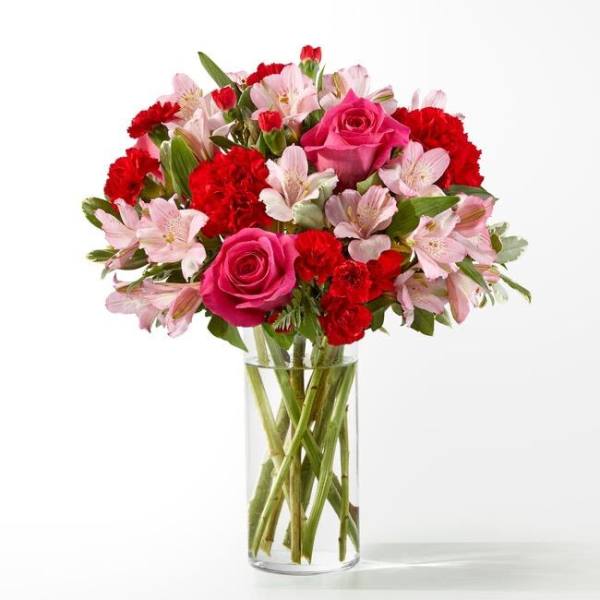 Pink roses and red carnations in a clear glass vase