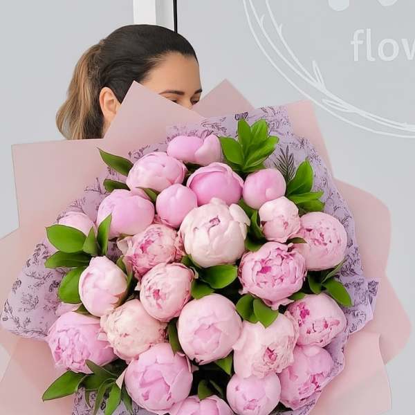 Large bouquet of pink peonies wrapped in pale pink paper