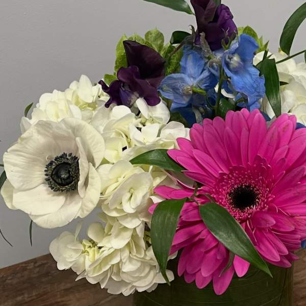 Bouquet with white hydrangeas, pink and white gerbera daisies, and blue and purple flowers