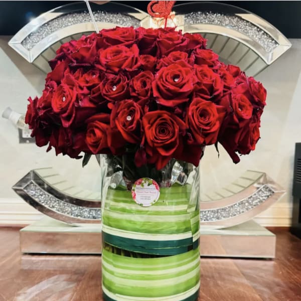 Large bouquet of red roses in a striped glass vase