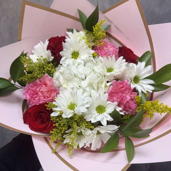 Bouquet of red roses, white daisies, pink carnations, and white hydrangea