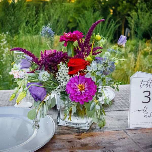 Colorful floral centerpiece in a clear glass vase on a table