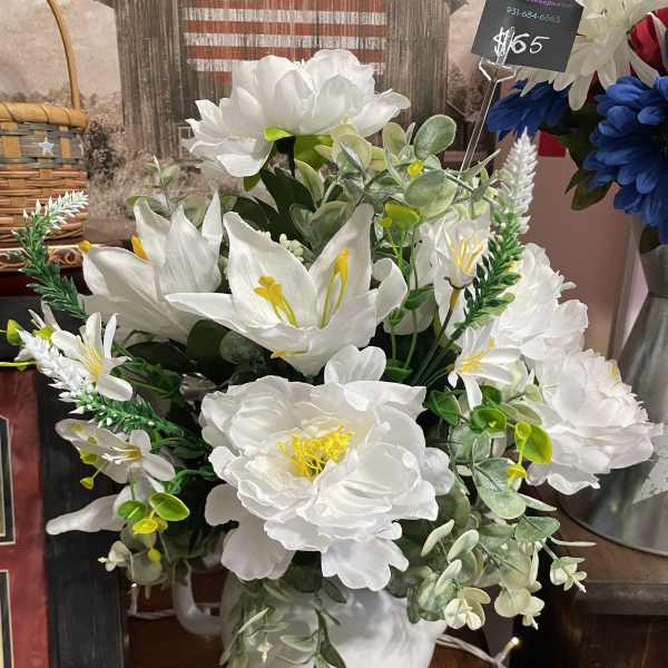 White floral arrangement in a white pitcher vase