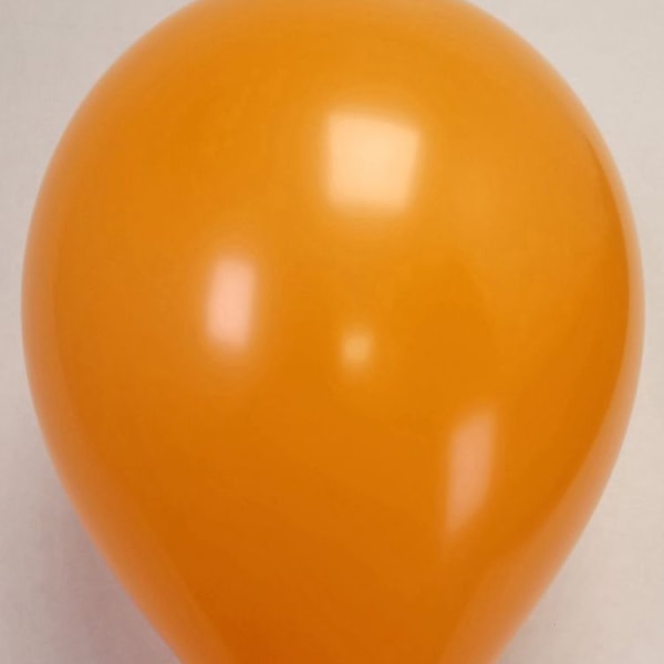 Single orange balloon on a plain background