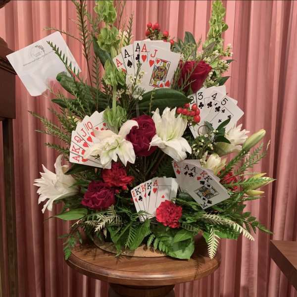 Large floral arrangement with playing cards and red and white flowers