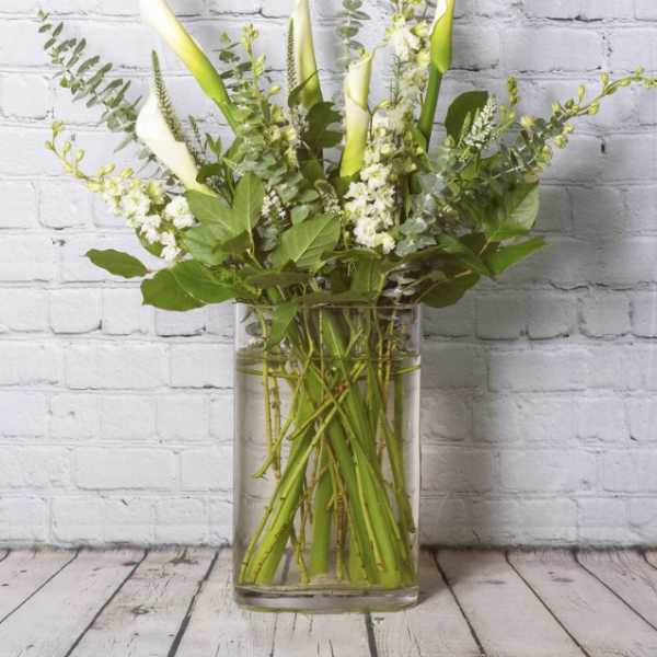 Tall white calla lily arrangement in a clear glass vase