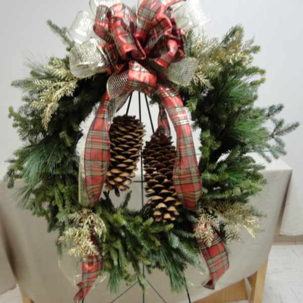 Christmas wreath with plaid ribbon and hanging pinecones