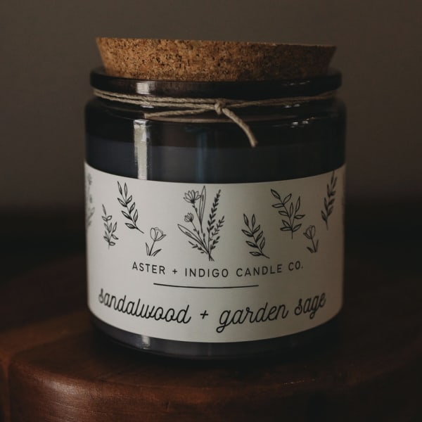 Dark glass candle jar with a cork lid and floral label