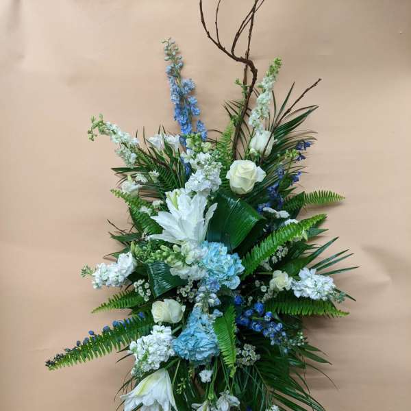 Tall floral spray with white and blue flowers on a stand