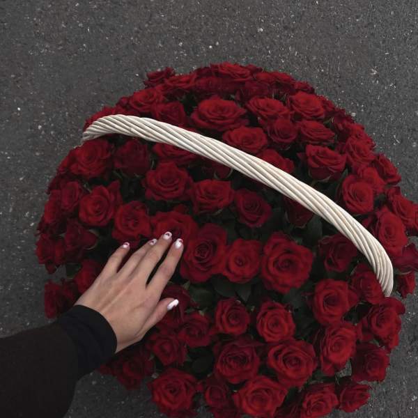 Basket filled with red roses and a white handle