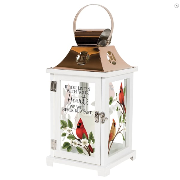 White memorial lantern with cardinal and floral artwork and a metal handle