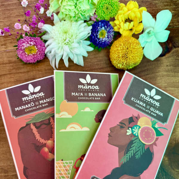 Three chocolate bars with colorful flower accents on a wooden surface.
