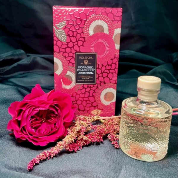 Pink rose with a patterned candle box and glass bottle