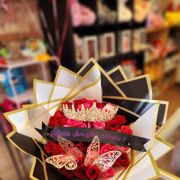 Bouquet of red and pink roses with a jeweled crown and butterfly decorations