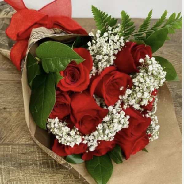 Bouquet of red roses with white baby's breath wrapped in brown paper