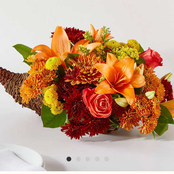 Orange and red flower arrangement in a woven basket