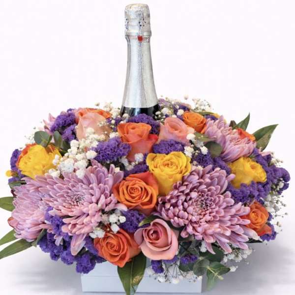 Mixed bouquet with roses and purple chrysanthemums around a champagne bottle