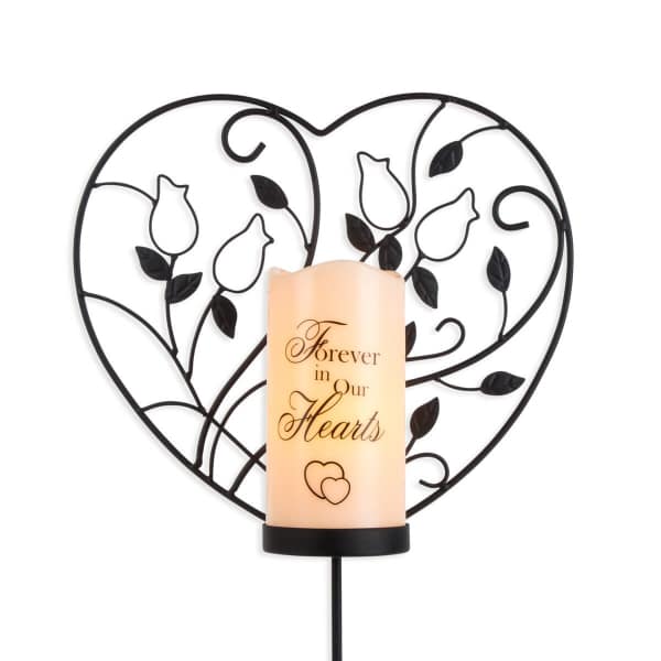 Heart-shaped memorial candle holder with a lit candle