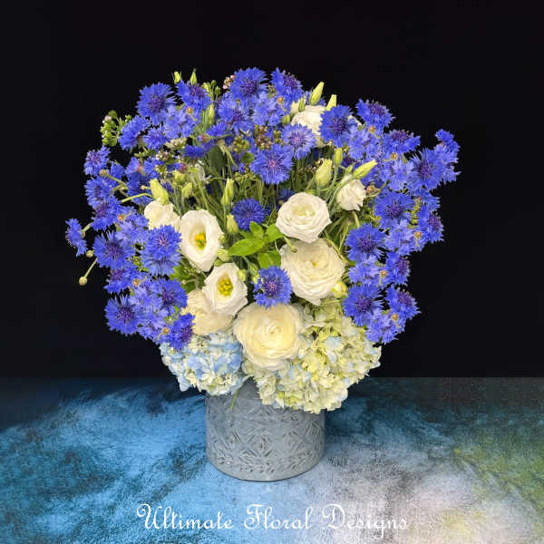 Blue and white floral arrangement in a gray textured vase