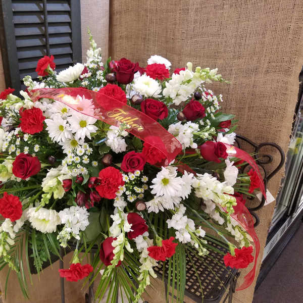 Red and white floral arrangement with a red ribbon reading Father