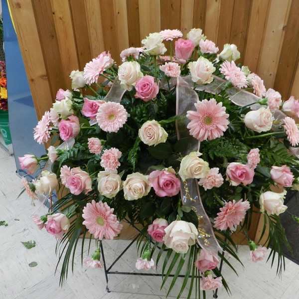 Large pink and white floral standing spray on a metal easel