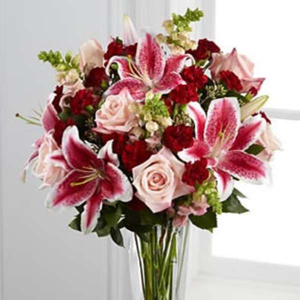 Bouquet of pink lilies and roses in a clear glass vase