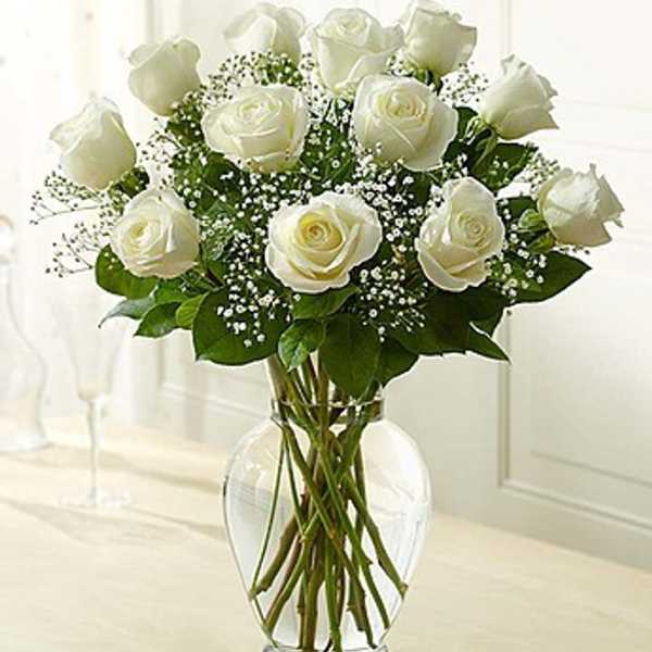 White roses arranged in a clear glass vase