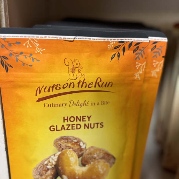 Box of honey glazed nuts with a yellow-orange label