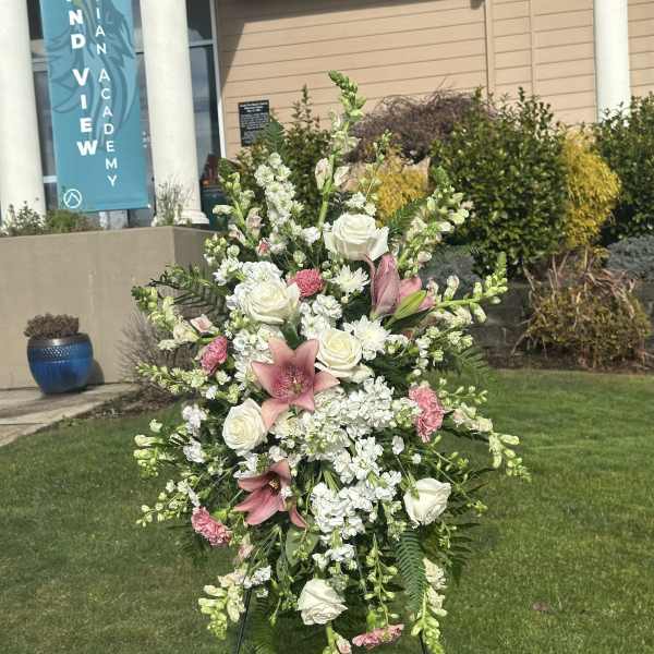 Standing floral spray with white roses, pink lilies, and white blooms