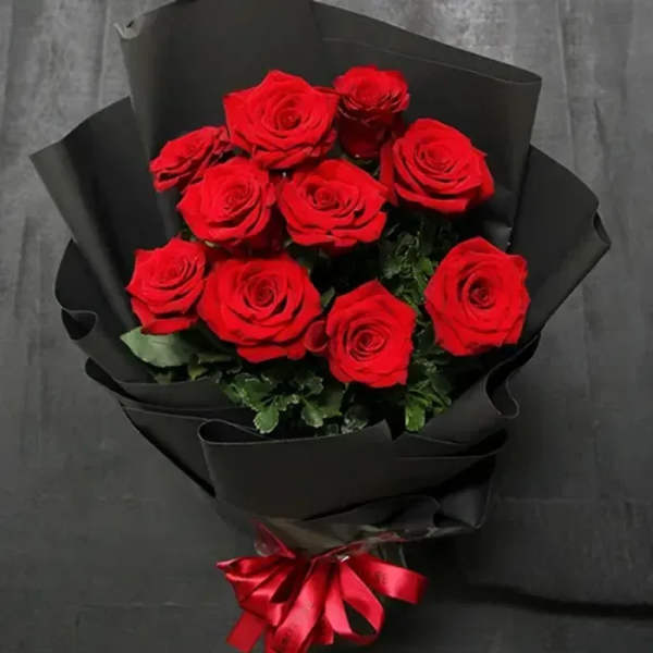 Bouquet of red roses wrapped in black paper with a red ribbon
