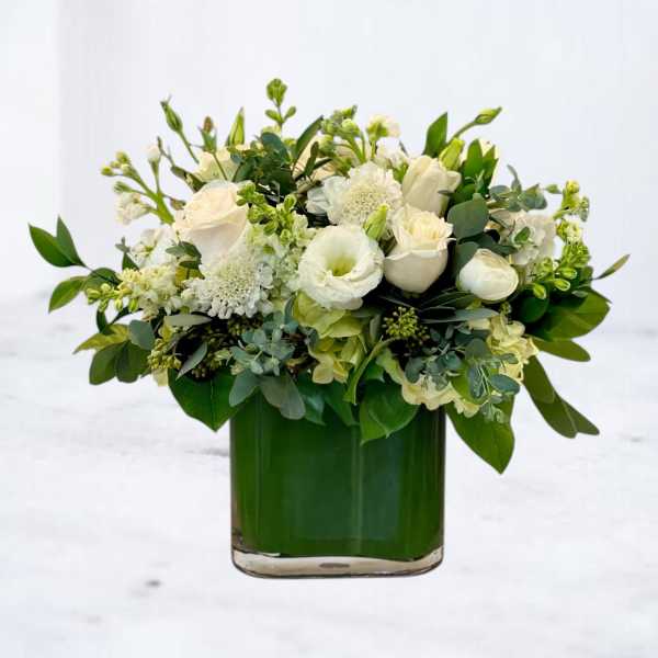 White floral arrangement in a green glass vase