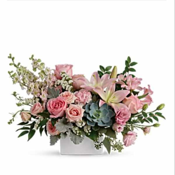 Pink roses and lilies in a white square vase with greenery