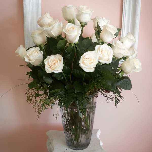 White roses arranged in a clear glass vase