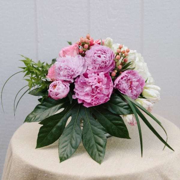 Pink peonies and white flowers arranged in a low bouquet