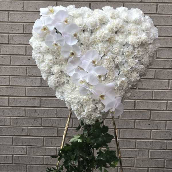 Heart-shaped white floral standing spray with orchids and greenery