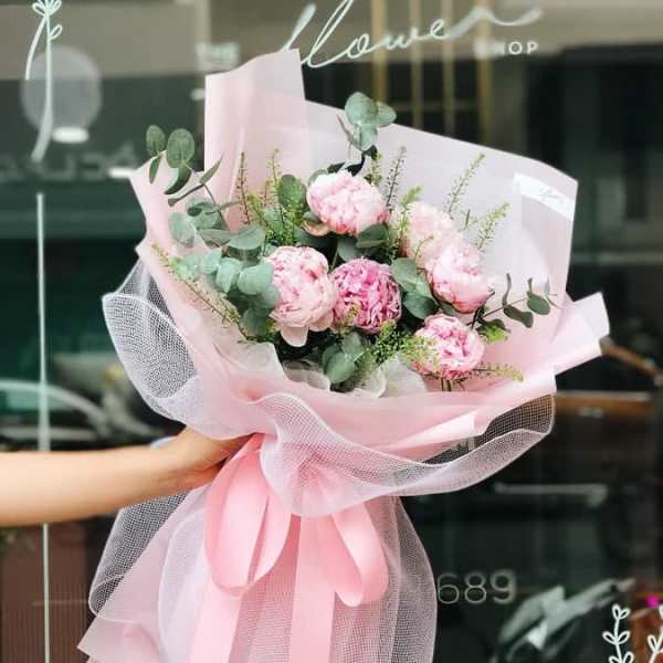 Pink peony bouquet wrapped in pale pink paper and tulle
