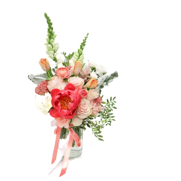 Pink and white bouquet in a glass vase with tall green spikes