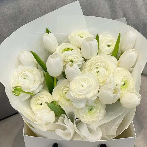 White tulips and ranunculus in white wrapping paper